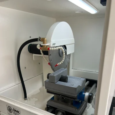 Core sample being cut during operation of the laboratory cutting machine.