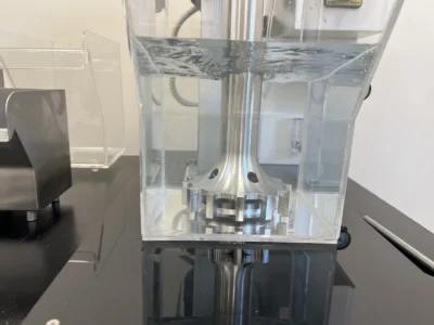 Fine air bubble dispersion in a transparent froth flotation cell during an aeration test, showing uniform agitation across the tank