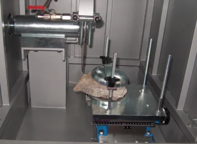 Cutting of an irregular-shaped rock sample during operation of the laboratory trimming machine.