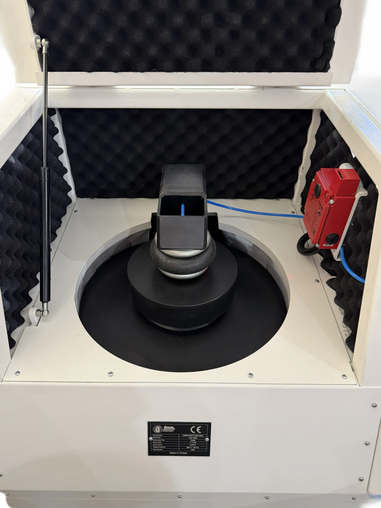 Close-up of unal pulverizer HO-1500 grinding chamber with pneumatic clamping air bellows, grinding bowl, safety interlock switch and acoustic foam lining
